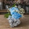 Blue and silver rose bouquet with baby's breath on a wooden table