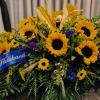 Large sunflower arrangement with a blue ribbon and mixed greenery