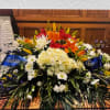 Large floral spray with lilies, white daisies, and hydrangeas in a church setting