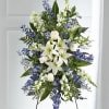 Tall standing floral spray with white lilies and blue flowers