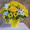 Yellow and white flower arrangement in a smiley-face mug