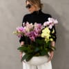 Woman holding a large bowl of pink and yellow orchids