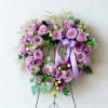 Lavender rose wreath with a ribbon bow on a stand