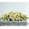 White and pale yellow floral spray on a silver casket