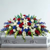 Red, white, and blue floral spray on a silver casket