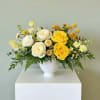Yellow and white rose arrangement in a white vase