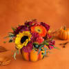 Autumn bouquet in a pumpkin-shaped container with sunflowers and orange blooms