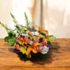 Mixed bouquet with orange lilies, peach roses, and white blooms on a wooden table