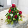 Small holiday floral arrangement with red roses and white daisies