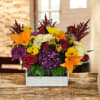 Mixed bouquet in a white wooden box with orange lilies, red roses, and purple hydrangea