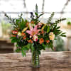 Mixed bouquet with pink lilies and roses in a clear glass vase