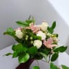 Pink lilies and white roses in a hand-tied bouquet