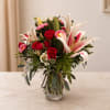 Red roses and pink lilies in a clear glass vase