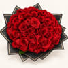 Large bouquet of red roses wrapped in black paper with gold trim