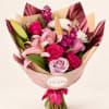 Bouquet of pink roses, lilies, and white chrysanthemums wrapped in pink paper