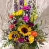 Tall mixed bouquet with sunflowers, roses, carnations, and purple blooms