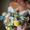 Bride holding a colorful bouquet of mixed flowers
