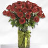 Bouquet of red roses in a glass vase with a green ribbon