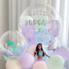 Pastel balloon arrangement with a doll and mermaid-themed clear balloons