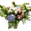 Pastel mixed bouquet in a clear glass vase with hydrangeas, roses, lilies, and carnations