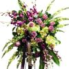 Large bouquet of purple orchids, pink roses, and green hydrangeas with a ribbon