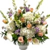 White hydrangeas, peach roses, and calla lilies in a white vase