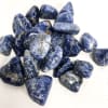Pile of polished blue stones with white veining on a white background