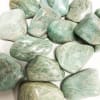 Polished green and white stones arranged on a white surface