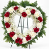 Heart-shaped wreath of red and white roses on a stand