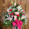 Pink roses, lilies, and carnations with a bright pink bow