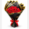 Bouquet of red roses wrapped in black and gold paper with a red ribbon