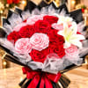 Bouquet of red and pink roses with white lilies wrapped in black paper
