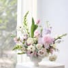 Pastel floral arrangement in a white vase with roses and tulips
