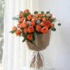 Bouquet of orange roses wrapped in brown paper