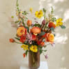 Orange and yellow mixed bouquet in a tall glass vase
