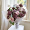 Pink roses and mauve carnations in white wrapping