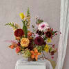 Mixed floral arrangement in a brown vase with tulips, roses, and dahlias