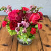 Pink and red flower arrangement in a clear glass vase