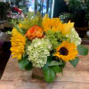 Sunflower and rose arrangement in a low glass vase