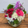 Pink roses and a gerbera daisy in a glass vase with white hydrangeas