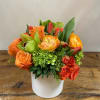 Orange and red rose bouquet in a white vase