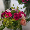 Bouquet of hot pink and peach roses with green filler flowers