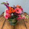 Colorful mixed bouquet in a glass vase with pink and orange blooms