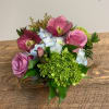 Pink roses and hydrangeas with dark hellebore blooms in a low bouquet