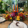 Colorful floral centerpiece with orange taper candles on a table