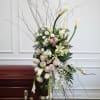 Tall floral arrangement with white calla lilies, pale roses, and pink accents
