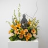 Orange floral arrangement with a decorative lantern centerpiece