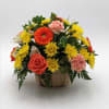 Mixed bouquet in a wooden container with orange, yellow, and pink flowers