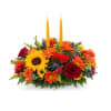 Bright floral centerpiece with two tall yellow candles