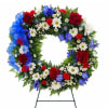 Circular floral wreath with red, white, and blue flowers on a stand